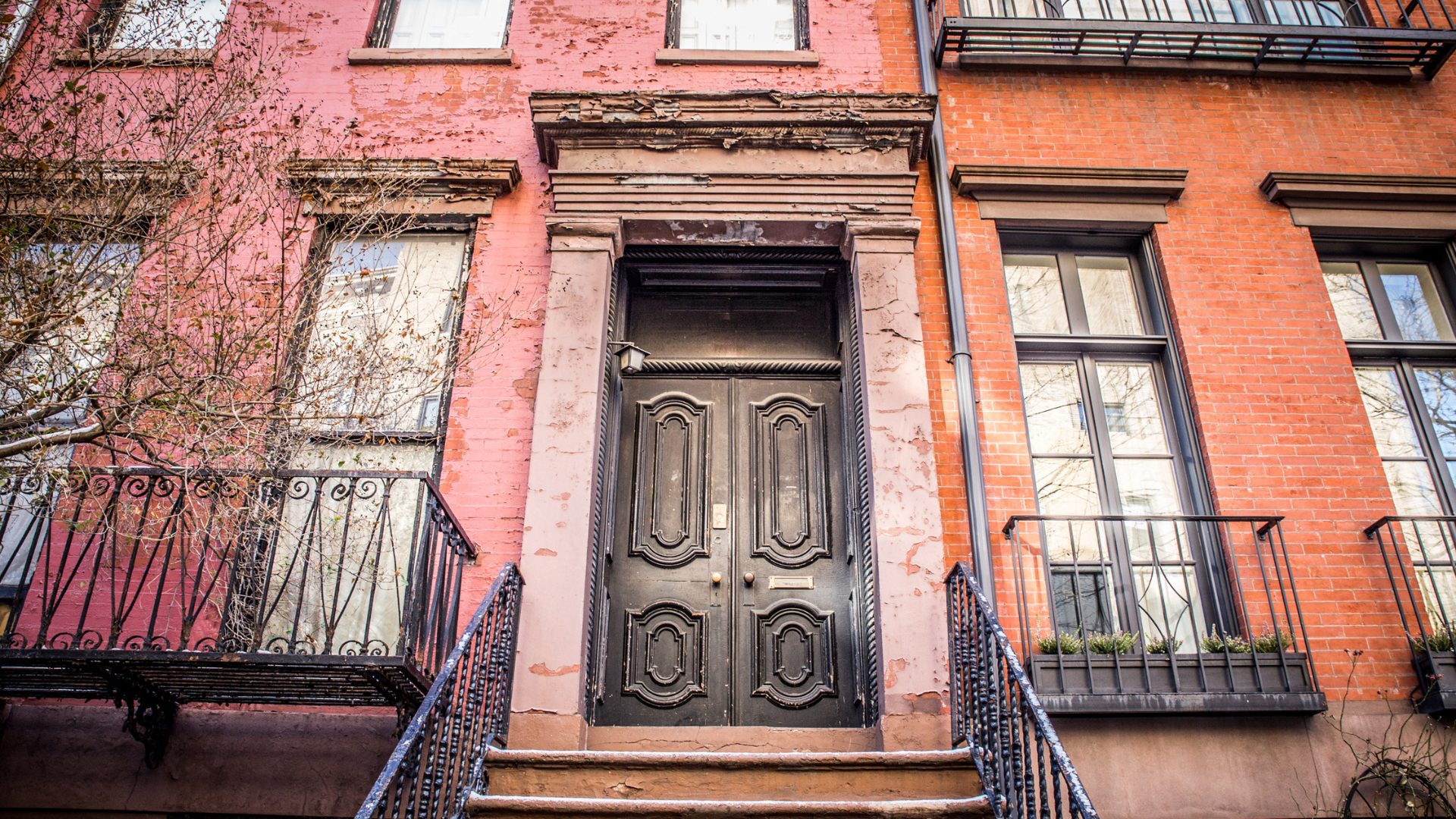 An old, weathered door in front of a New York apartment home.