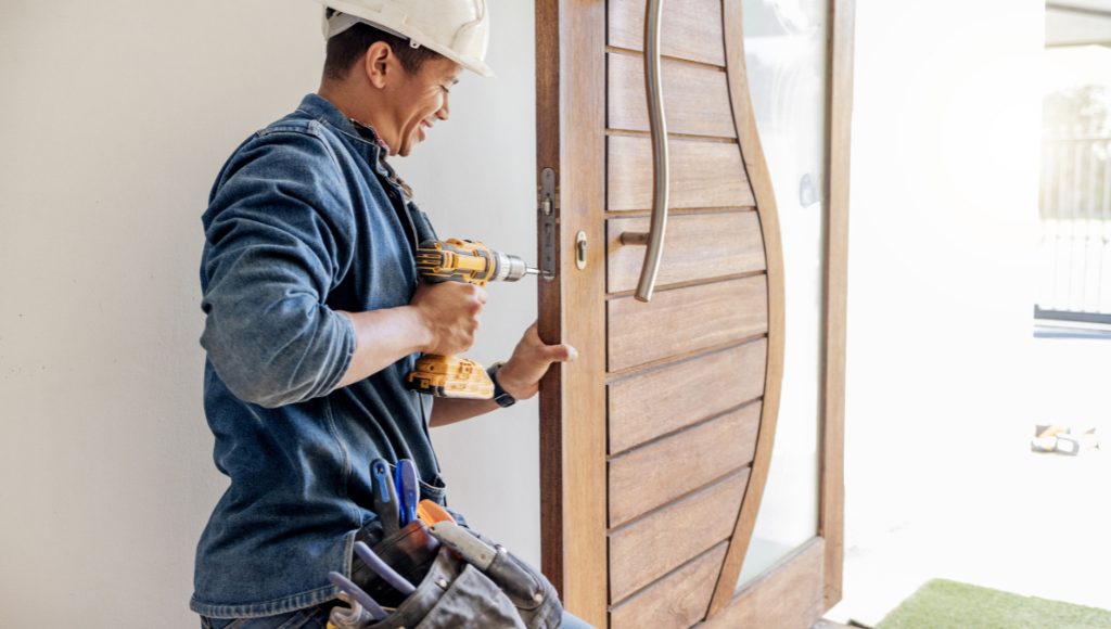 A professional installs a new front door on a home.