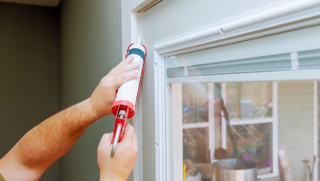 Close up of a door being caulked to prevent air from entering in the gaps.