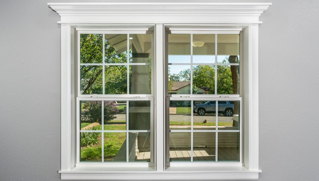 Double-hung windows in a suburban home, looking out on the front yard.