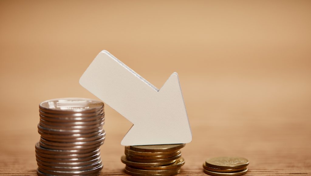 A white down-pointing arrow on three piles of coins in decreasing size.
